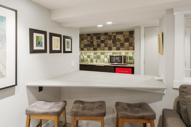 bar featuring tasteful backsplash and sink