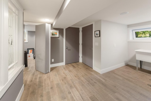 basement with light hardwood / wood-style flooring