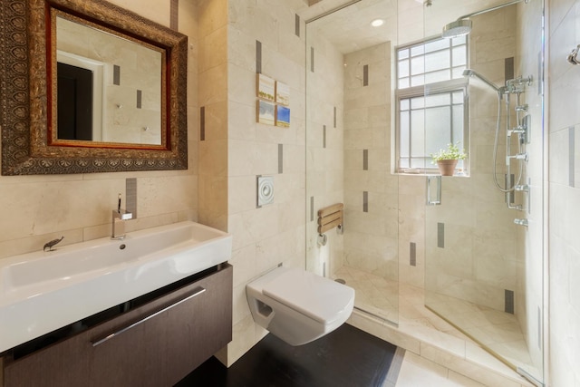 bathroom with tile walls, an enclosed shower, vanity, and toilet