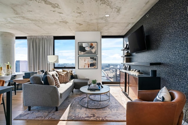 living room with plenty of natural light, expansive windows, and wood-type flooring