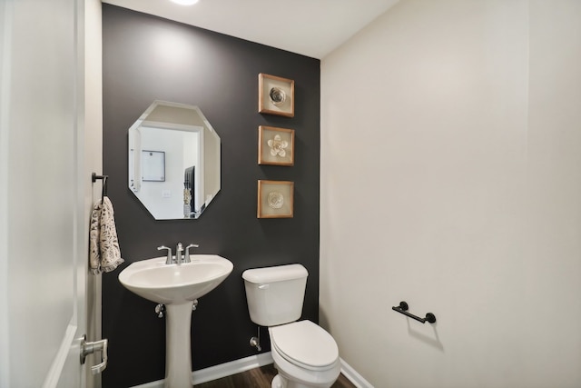 bathroom featuring toilet, wood-type flooring, and sink