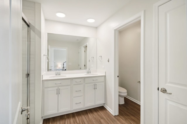 bathroom featuring vanity, toilet, walk in shower, and hardwood / wood-style floors