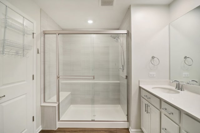 bathroom with vanity, hardwood / wood-style flooring, and walk in shower