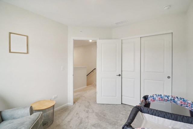 bedroom featuring a closet and light colored carpet