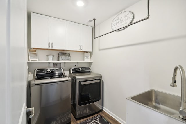 washroom with dark hardwood / wood-style flooring, sink, independent washer and dryer, and cabinets