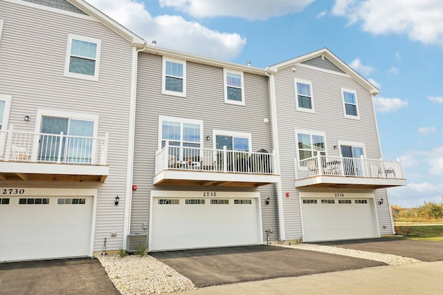 view of front facade with central air condition unit, a garage, and a balcony