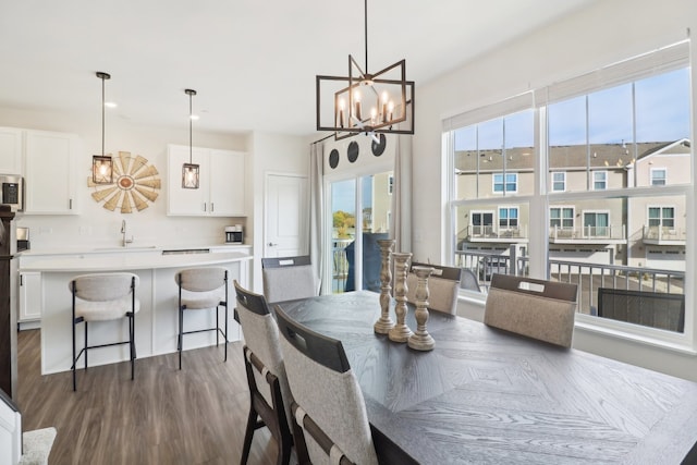 dining space featuring sink, dark hardwood / wood-style floors, and a chandelier