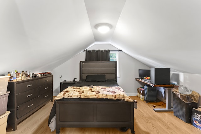 bedroom with light wood-type flooring and lofted ceiling