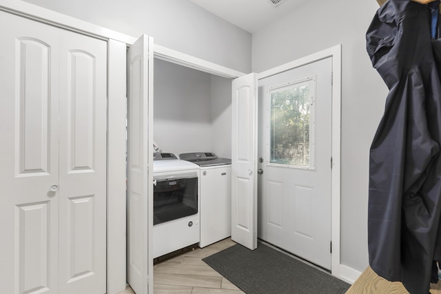 washroom with light wood-type flooring and washer and dryer