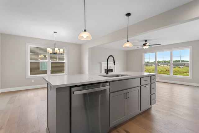 kitchen with sink, hanging light fixtures, stainless steel dishwasher, gray cabinets, and a center island with sink