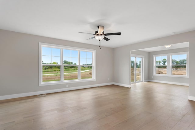 empty room with ceiling fan and light hardwood / wood-style flooring