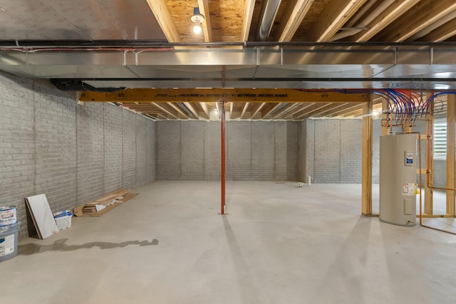 basement with electric water heater and brick wall