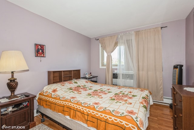 bedroom featuring wood-type flooring and baseboard heating