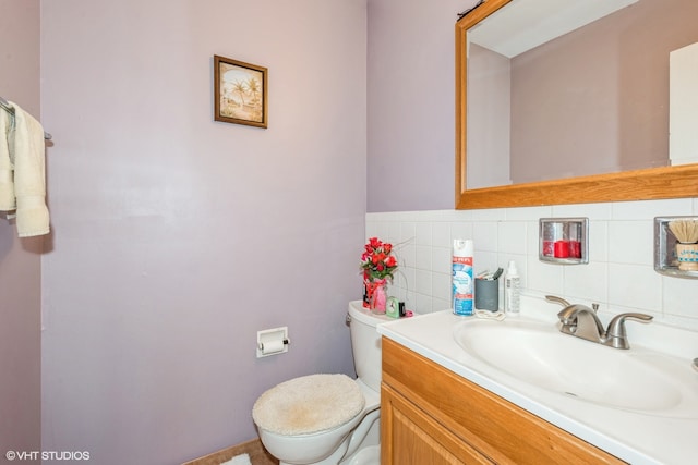 bathroom with vanity, toilet, and decorative backsplash