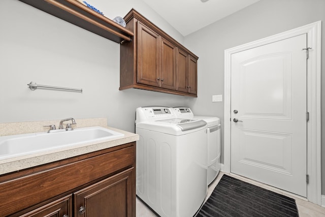 washroom with sink, cabinets, and washer and dryer