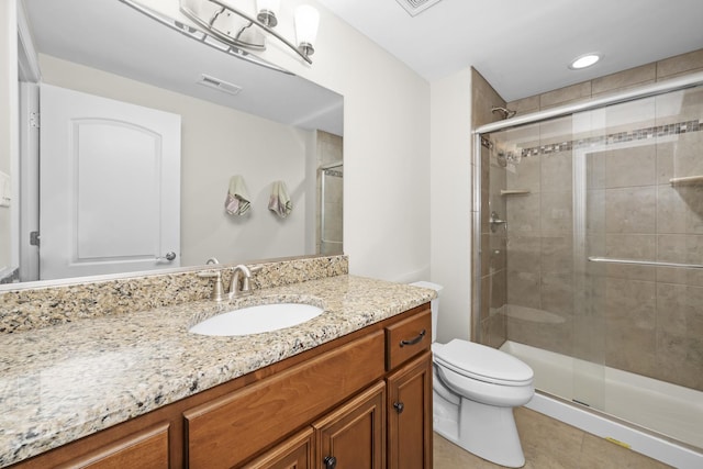 bathroom with tile patterned floors, toilet, a shower with door, and vanity