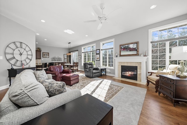 living room featuring a fireplace, hardwood / wood-style flooring, a wealth of natural light, and ceiling fan