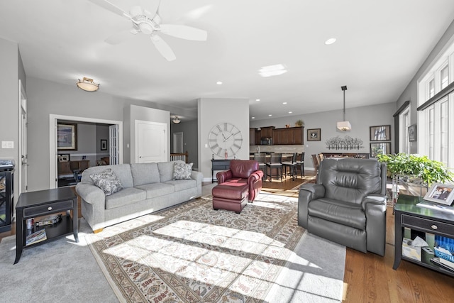 living room with ceiling fan and light hardwood / wood-style flooring