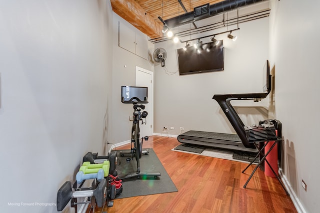 workout area featuring a high ceiling and hardwood / wood-style flooring