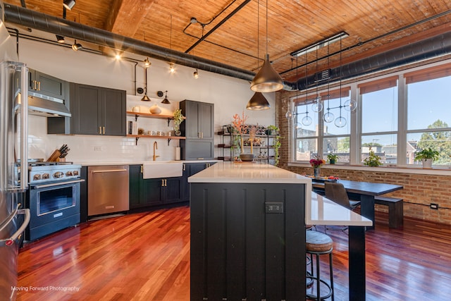 kitchen featuring wood-type flooring, appliances with stainless steel finishes, wooden ceiling, and a kitchen island