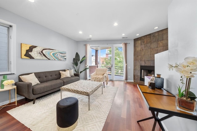 living room featuring hardwood / wood-style flooring and a tiled fireplace