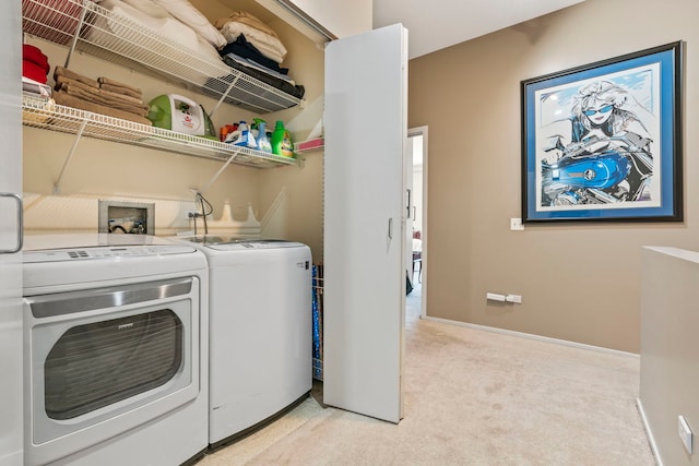 laundry room with washer and clothes dryer and light colored carpet