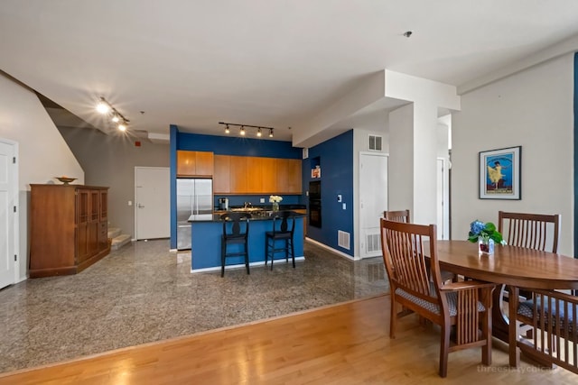 dining space featuring wood-type flooring and rail lighting