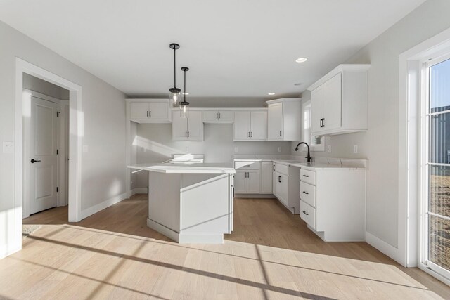 kitchen with pendant lighting, a center island, and white cabinetry