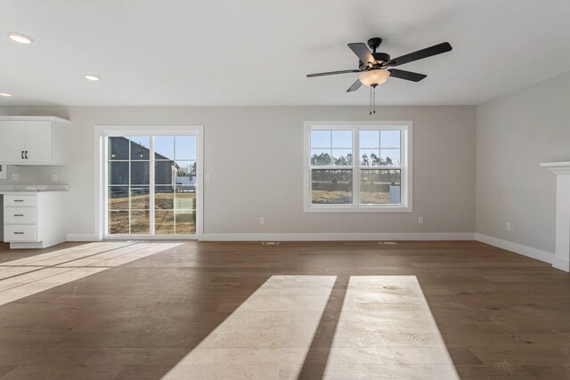 unfurnished living room featuring a fireplace, ceiling fan with notable chandelier, and light hardwood / wood-style flooring