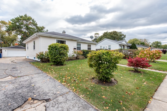 view of front of house with a front yard, an outbuilding, and a garage