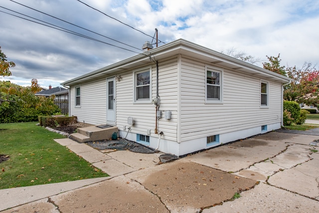 view of property exterior with a patio and a yard