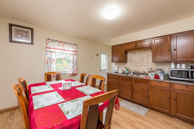 kitchen featuring sink, light wood-type flooring, and tasteful backsplash