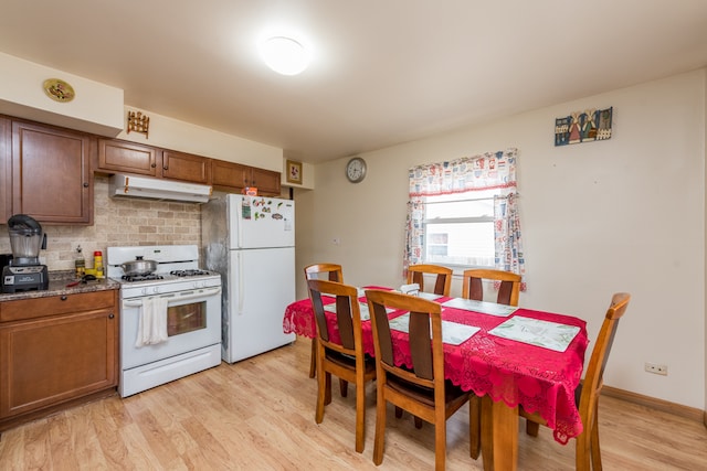 kitchen featuring tasteful backsplash, light wood-type flooring, and white appliances