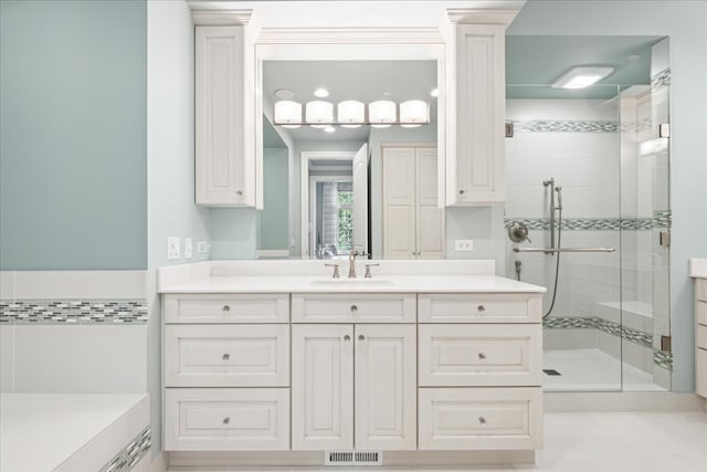 bathroom featuring vanity, a shower with shower door, and decorative columns