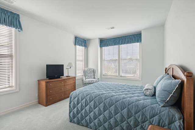 bedroom with light carpet and multiple windows