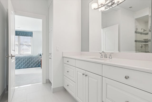 bathroom with a shower with door, tile patterned floors, and vanity