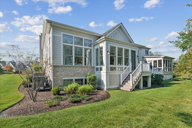 back of house featuring a yard and a sunroom