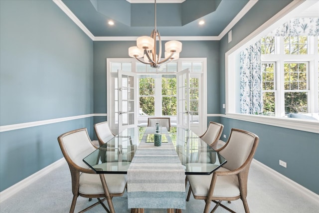 carpeted dining space featuring french doors, crown molding, a notable chandelier, and a wealth of natural light