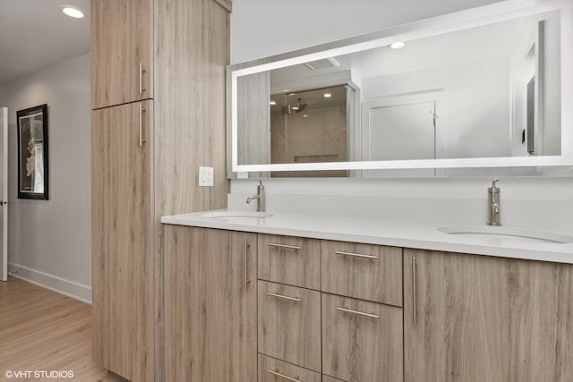 bathroom featuring vanity, walk in shower, and wood-type flooring