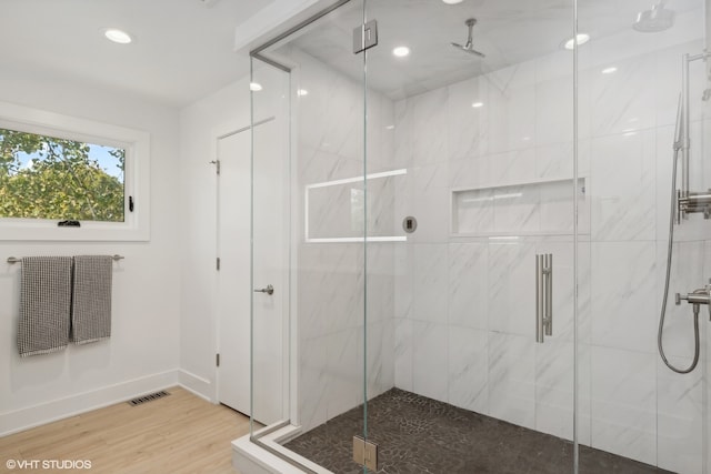 bathroom with a shower with door and wood-type flooring