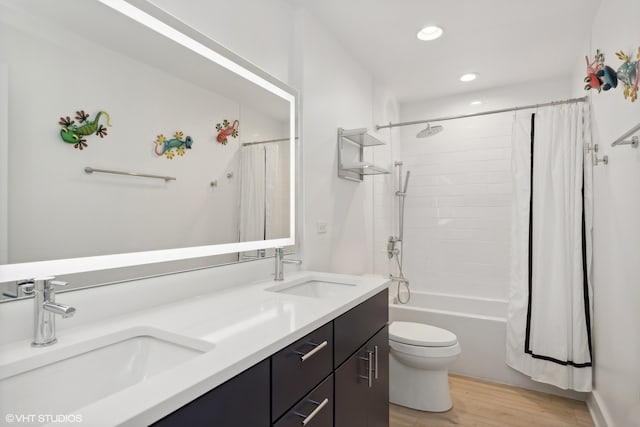 full bathroom featuring vanity, hardwood / wood-style floors, shower / bath combination with curtain, and toilet