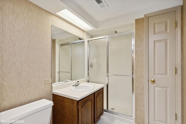 bathroom with vanity, toilet, walk in shower, and tile patterned flooring