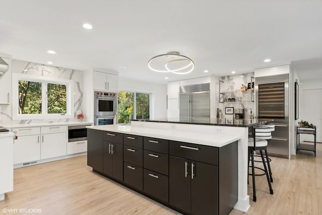 kitchen with appliances with stainless steel finishes, white cabinetry, a center island, and plenty of natural light