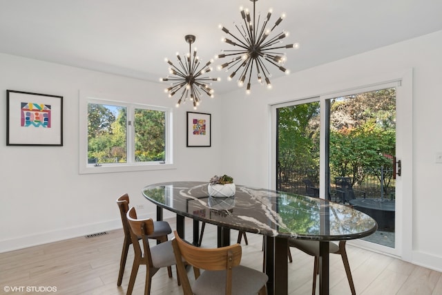 dining area featuring an inviting chandelier and light hardwood / wood-style floors