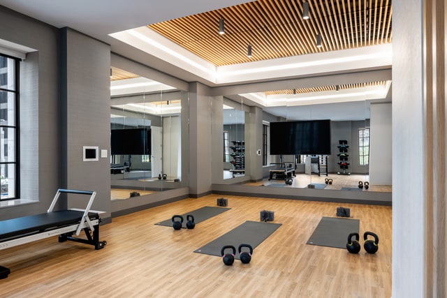 workout area featuring hardwood / wood-style floors, a healthy amount of sunlight, and a raised ceiling