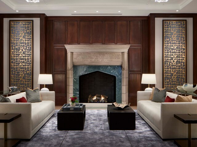 living room featuring a premium fireplace, ornamental molding, and a raised ceiling