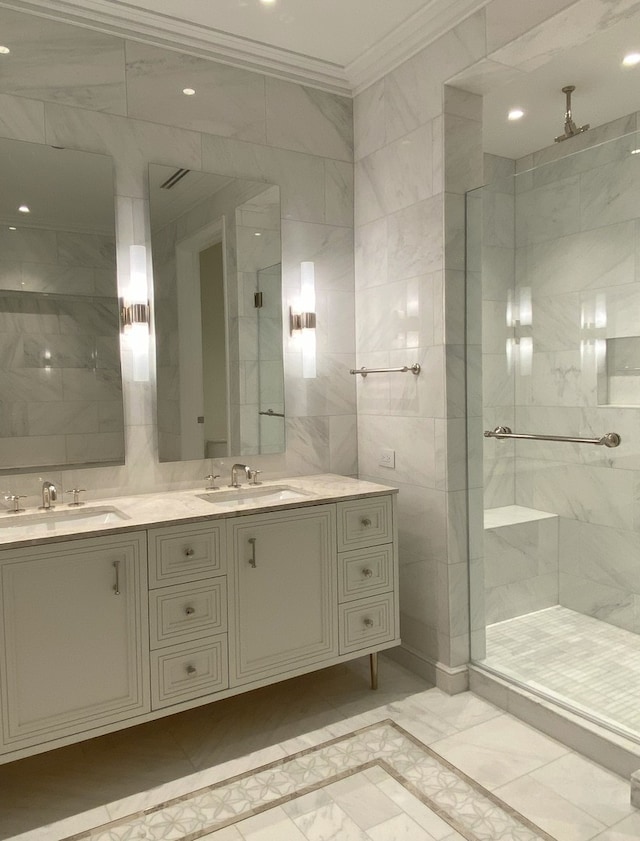 bathroom with vanity, ornamental molding, a shower with door, and tile walls