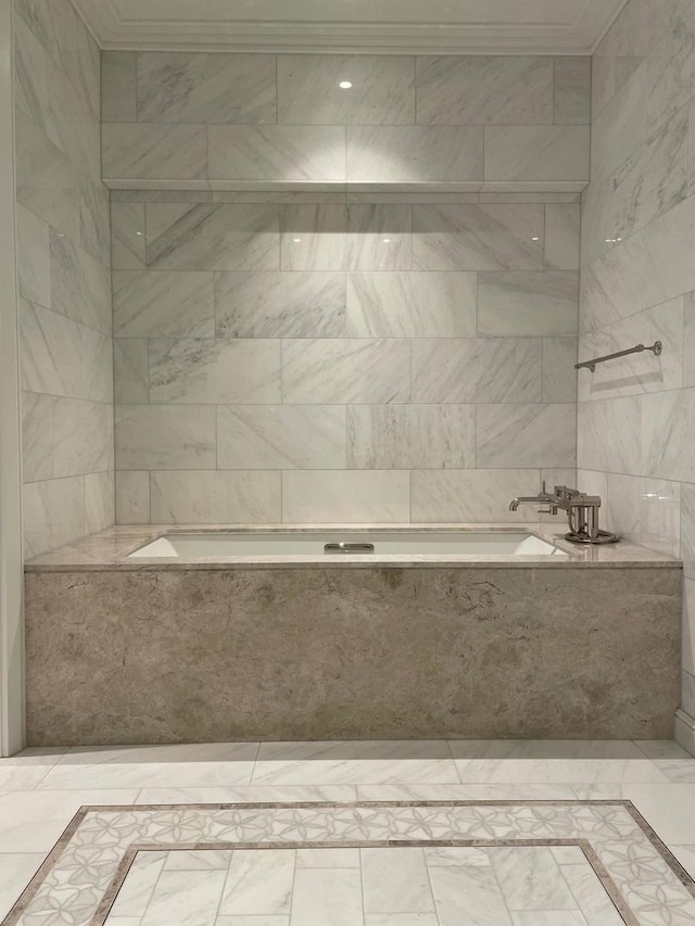 bathroom featuring a relaxing tiled tub, ornamental molding, and tile patterned floors