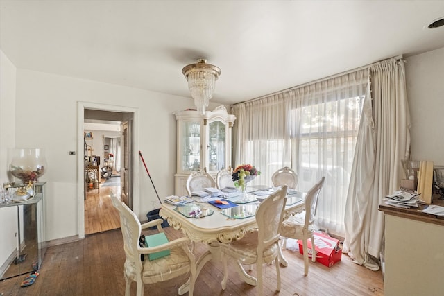 dining area featuring a notable chandelier and dark wood-type flooring