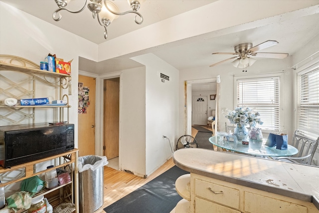 interior space with hardwood / wood-style flooring and ceiling fan with notable chandelier